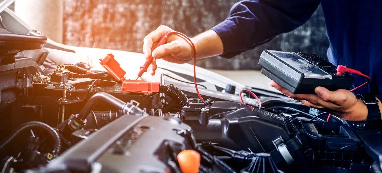 Měření elektrické soustavy vozu přístrojem v motorovém prostoru